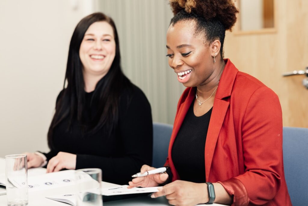 two women sat having an enjoyable conversation laughing multi-generational career conversations programme Antoinette Oglethorpe