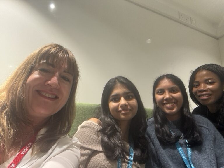 Antoinette Oglethorpe at a careers fair at her old school presenting her talk 'From Corporate Learning to Entrepreneurship: Empowering Growth and Mentorship' about her own career milestones, selfie image with 3 female sixth-form students and Antoinette.