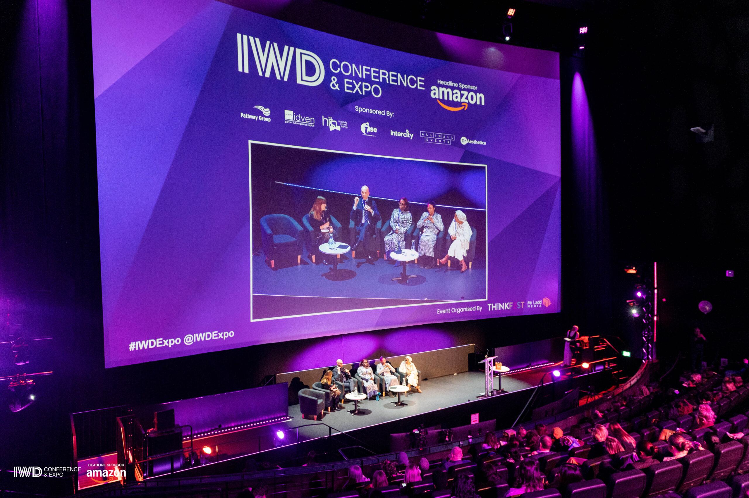 A view of the stage and an expert panel at the International Women’s Day Conference and Expo 2025 as they discuss equity, diversity and inclusion in the office.